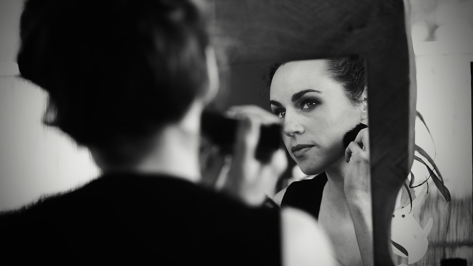 a woman is looking in the mirror while brushing her teeth