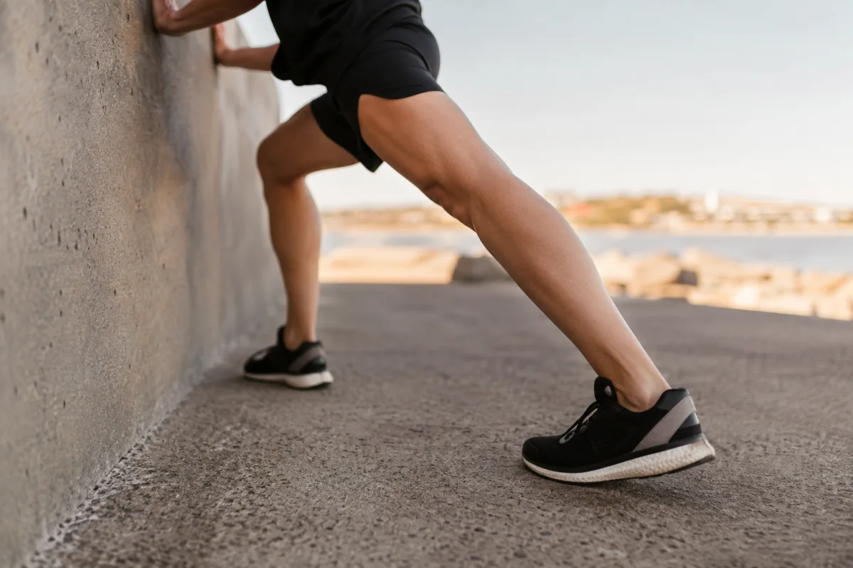 Gros plan sur le pied positionné en appui sur une marche d'escalier pour étirer le bas de la jambe