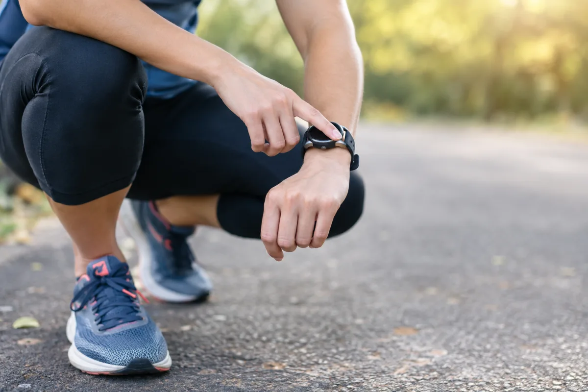 Gros plan sur les lacets ajustés d'une chaussure de running posée sur l'herbe humide d'un sous-bois