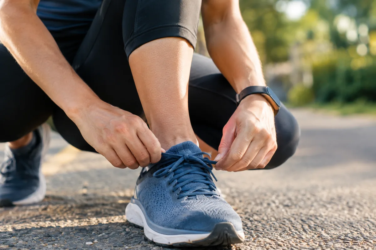 Gros plan sur les chaussures d un coureur laçées posées sur un chemin de terre en sous bois